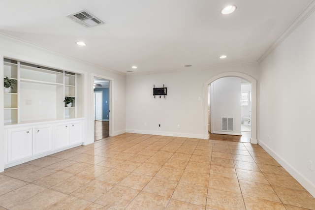 unfurnished room with visible vents, arched walkways, baseboards, and ornamental molding