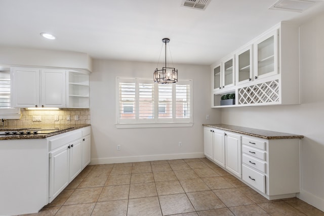 kitchen with decorative backsplash, white cabinets, an inviting chandelier, and open shelves