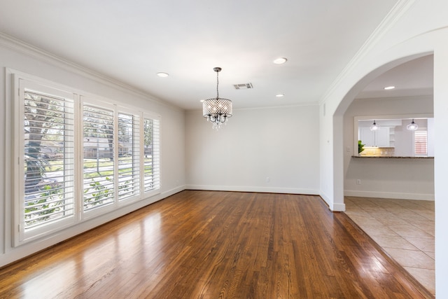 interior space with visible vents, wood finished floors, an inviting chandelier, crown molding, and baseboards