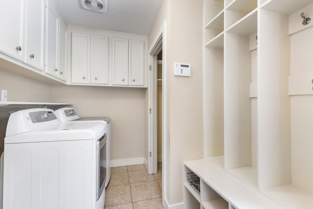 laundry room with visible vents, washer and dryer, cabinet space, light tile patterned floors, and baseboards