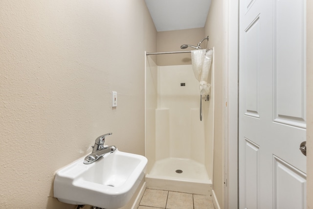 bathroom featuring a sink, a shower stall, and tile patterned flooring