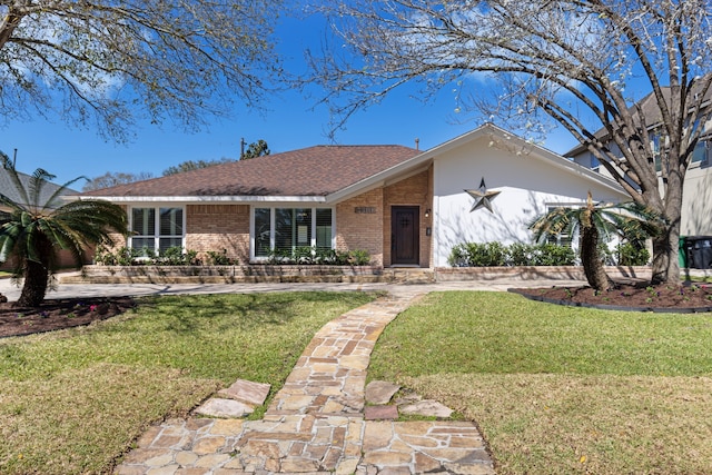 view of front facade with brick siding and a front yard