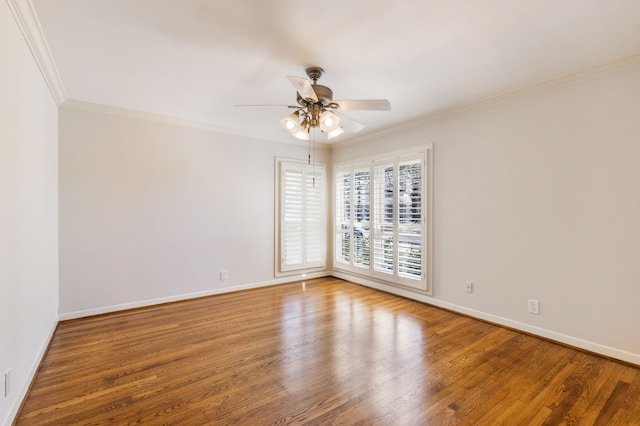 empty room with crown molding, wood finished floors, baseboards, and ceiling fan