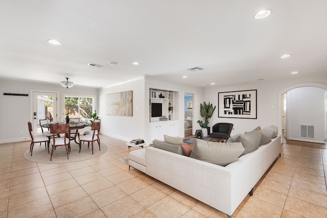 living area with arched walkways, visible vents, recessed lighting, and light tile patterned floors