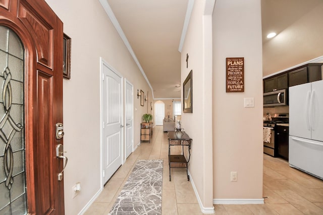 entryway featuring light tile patterned floors, baseboards, and ornamental molding