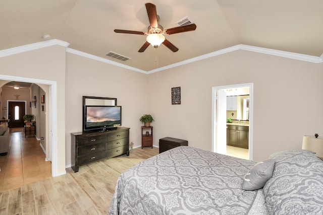 bedroom featuring light wood-type flooring, lofted ceiling, arched walkways, and visible vents