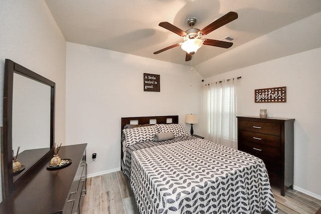 bedroom with visible vents, baseboards, vaulted ceiling, and light wood finished floors