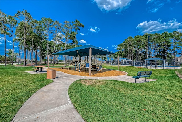 surrounding community featuring a lawn, playground community, and fence