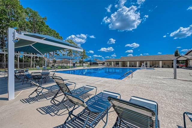 pool with a patio area and fence