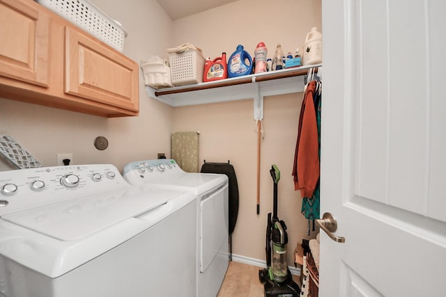 washroom with baseboards, cabinet space, light wood-style flooring, and washer and clothes dryer