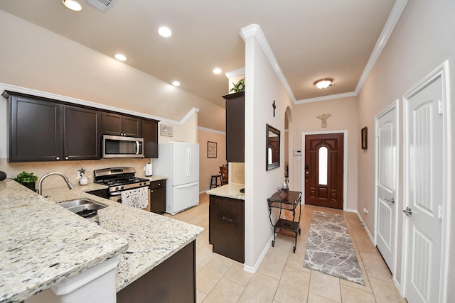 kitchen featuring a sink, stainless steel appliances, dark brown cabinetry, crown molding, and light stone countertops