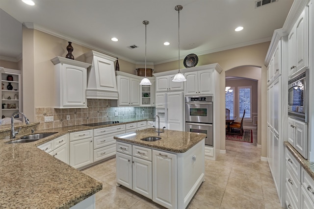 kitchen featuring custom range hood, arched walkways, built in appliances, and a sink