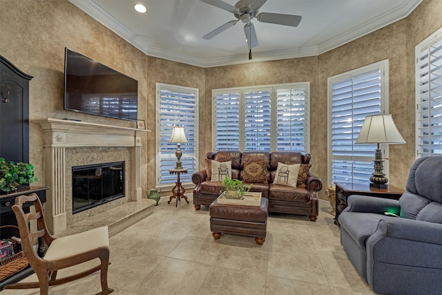 living room with a high end fireplace, ceiling fan, crown molding, and tile patterned flooring