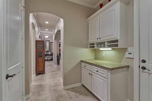 interior space featuring crown molding, baseboards, recessed lighting, light tile patterned flooring, and arched walkways