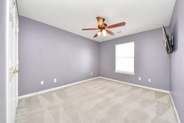 unfurnished room with ceiling fan, visible vents, baseboards, and light carpet