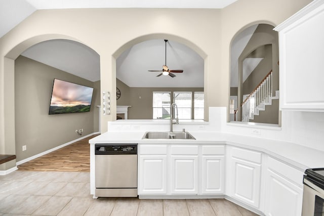 kitchen with a ceiling fan, a sink, stainless steel appliances, light countertops, and lofted ceiling