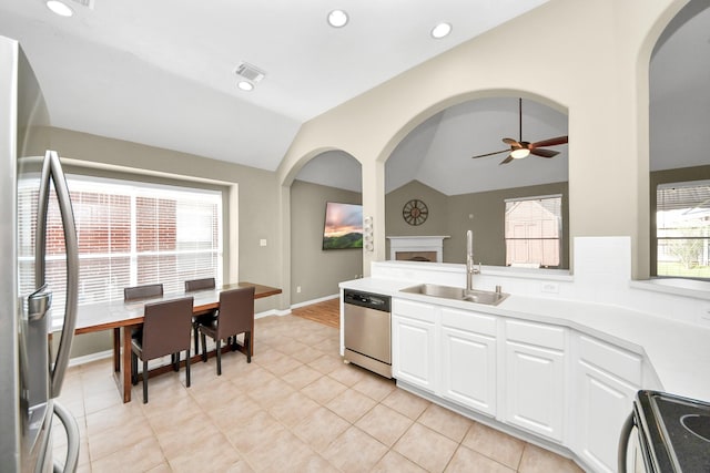 kitchen with visible vents, a sink, white cabinetry, appliances with stainless steel finishes, and vaulted ceiling