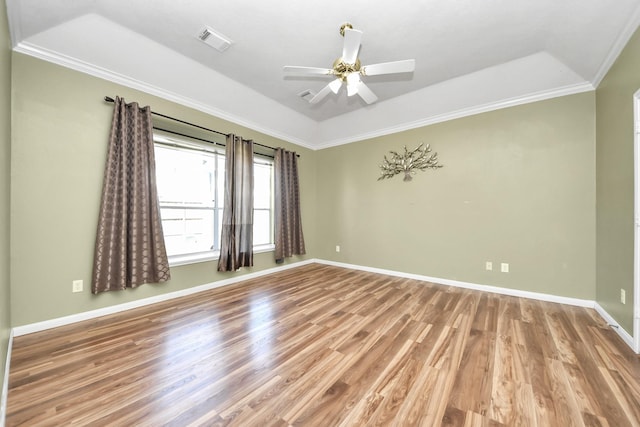 empty room featuring visible vents, crown molding, ceiling fan, baseboards, and wood finished floors