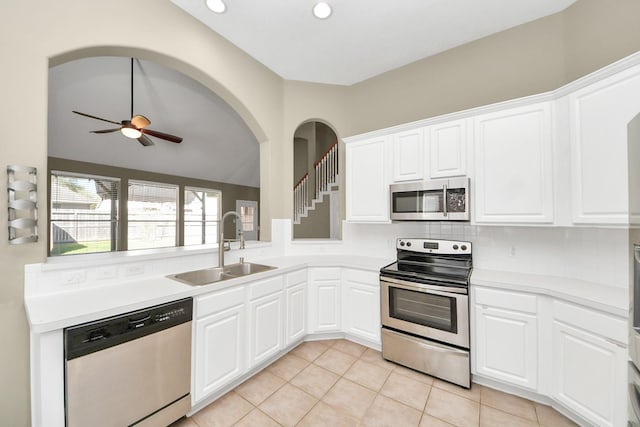 kitchen featuring light countertops, light tile patterned floors, stainless steel appliances, a ceiling fan, and a sink