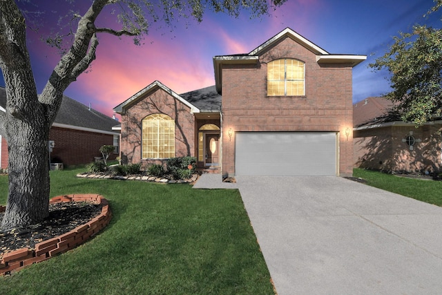 traditional-style house with concrete driveway, an attached garage, a lawn, and brick siding