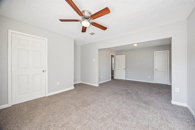 unfurnished room featuring visible vents, baseboards, carpet flooring, a textured ceiling, and a ceiling fan