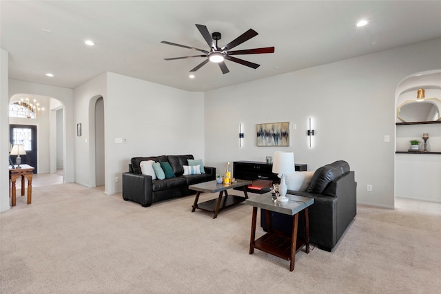 living area featuring recessed lighting, light carpet, and arched walkways