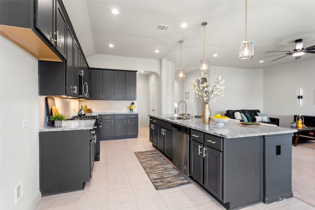 kitchen with arched walkways, a sink, stainless steel appliances, a large island, and open floor plan