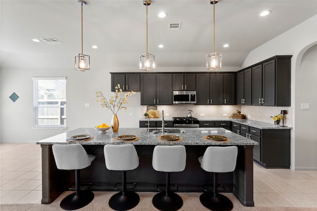 kitchen with stove, stainless steel microwave, visible vents, and light tile patterned floors