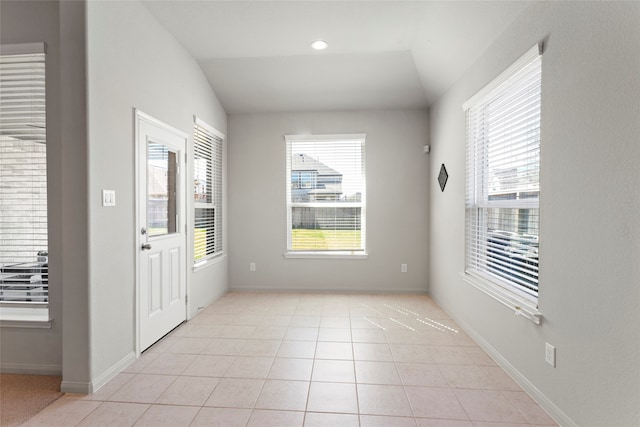 entrance foyer with light tile patterned flooring, baseboards, and vaulted ceiling