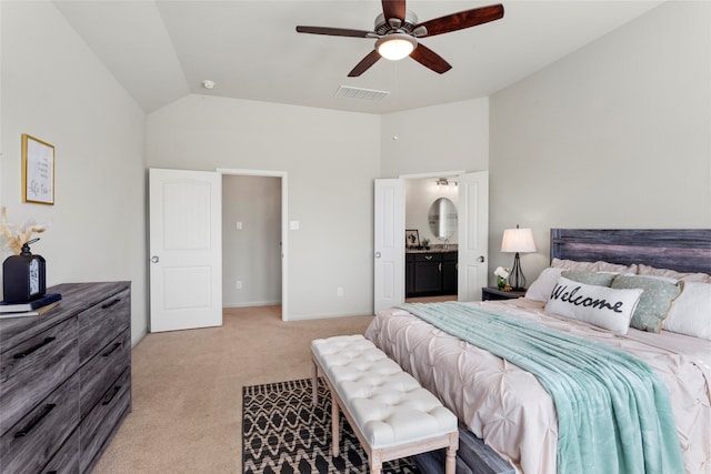 bedroom featuring visible vents, ceiling fan, light colored carpet, lofted ceiling, and ensuite bath