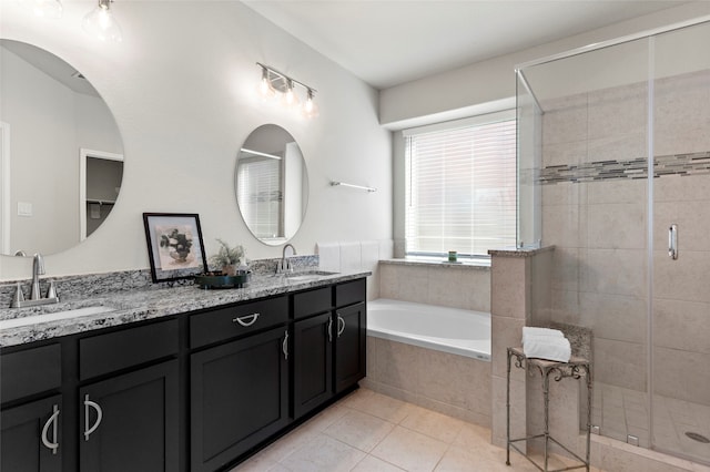 bathroom featuring a sink, a garden tub, a stall shower, and double vanity