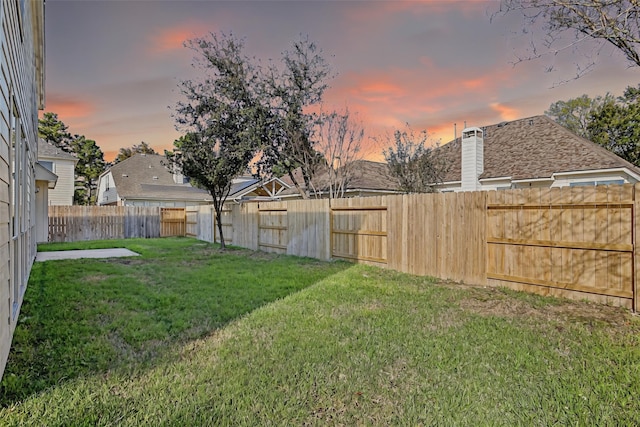 yard at dusk with a fenced backyard