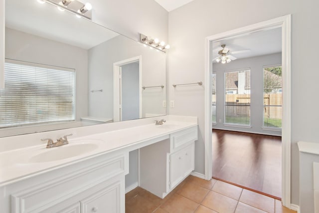 bathroom featuring tile patterned flooring, double vanity, ceiling fan, and a sink