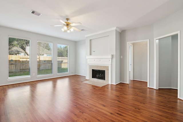 unfurnished living room featuring visible vents, wood finished floors, baseboards, ceiling fan, and a tile fireplace