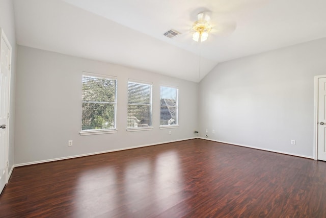 spare room featuring lofted ceiling, baseboards, dark wood-type flooring, and ceiling fan