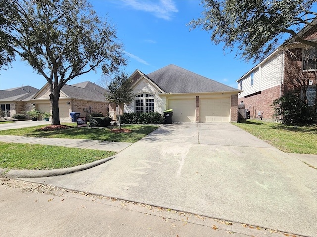 view of front of house with brick siding, an attached garage, concrete driveway, and a front yard