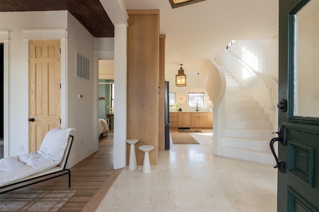 foyer featuring stairs and visible vents