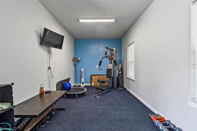 exercise room with baseboards and carpet