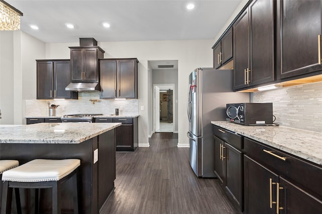 kitchen featuring under cabinet range hood, dark wood-style floors, dark brown cabinetry, range, and light stone countertops