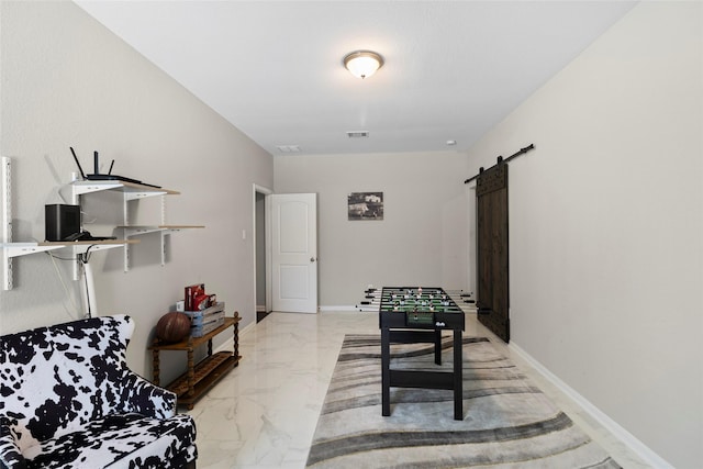 living area with visible vents, marble finish floor, baseboards, and a barn door