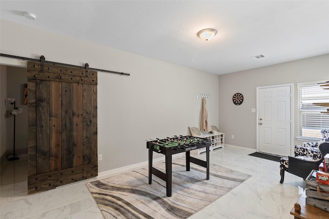 interior space with visible vents, marble finish floor, baseboards, and a barn door