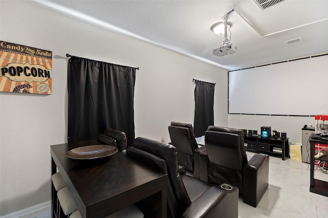 cinema with visible vents, marble finish floor, and a textured ceiling