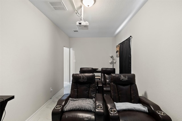 cinema featuring visible vents, baseboards, and a textured ceiling