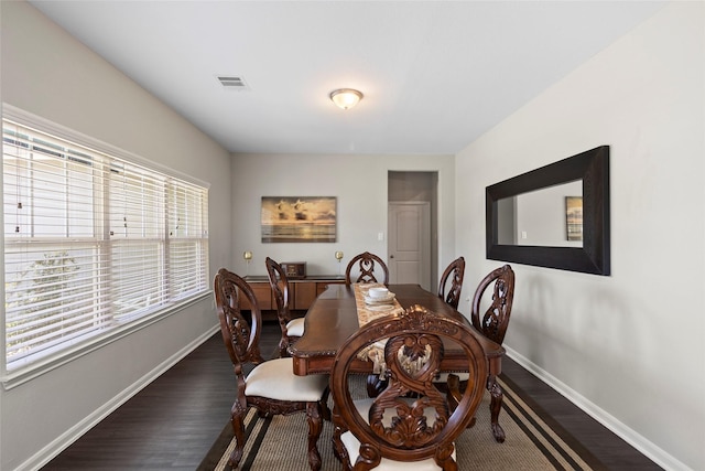 dining space featuring baseboards, visible vents, and dark wood-style flooring