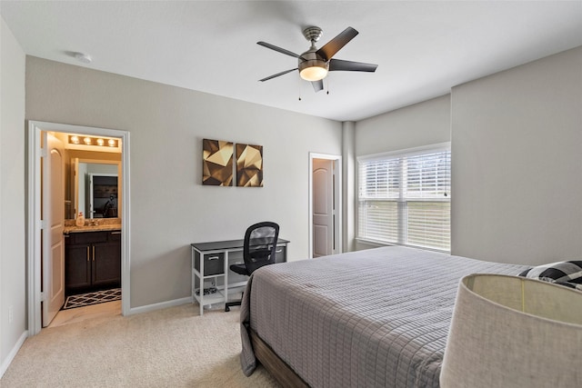 bedroom with ensuite bath, light colored carpet, a ceiling fan, and baseboards