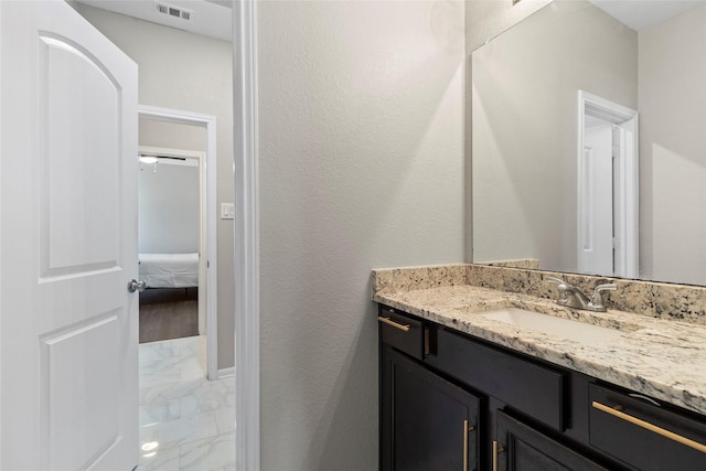 bathroom with vanity, visible vents, and marble finish floor