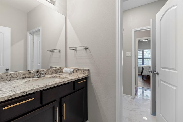 bathroom featuring baseboards, marble finish floor, ensuite bath, and vanity