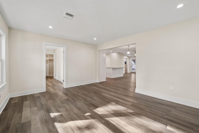 unfurnished living room with recessed lighting, baseboards, visible vents, and dark wood-style flooring