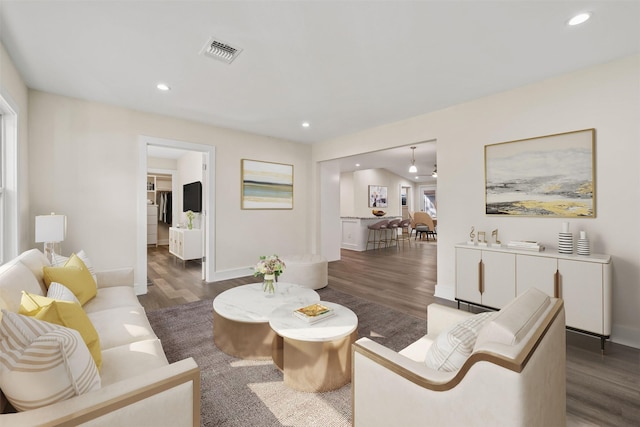 living room featuring visible vents, recessed lighting, baseboards, and dark wood-style flooring