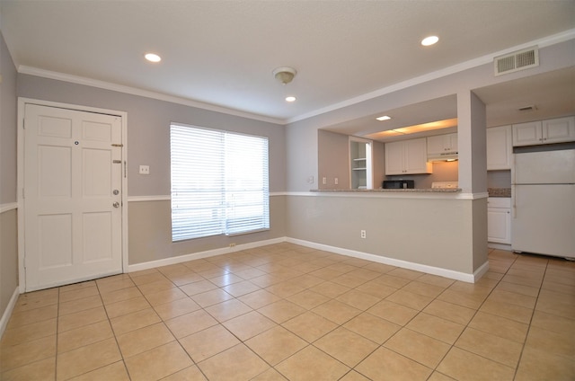 entryway featuring light tile patterned floors, baseboards, and crown molding